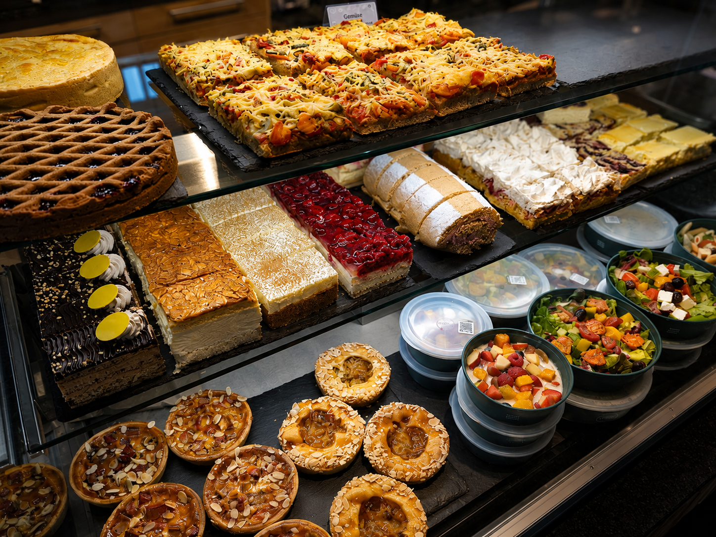 Bistrotheke mit Kuchen, Pizzaschnitten und Salaten